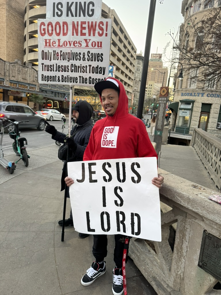 Man holding a Jesus is Lord sign during outreach