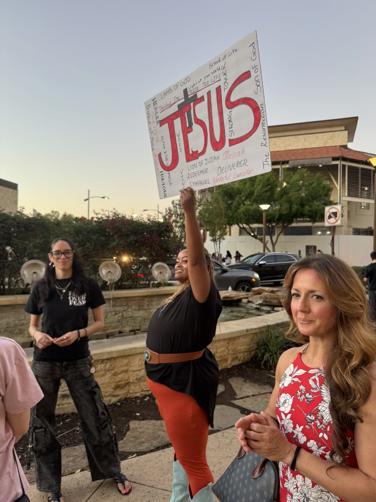 People holding a Jesus sign during street ministry