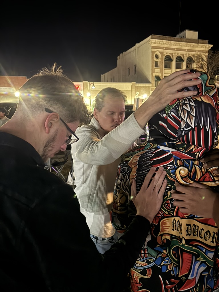Jesus People 2.0 praying with someone outdoors at night